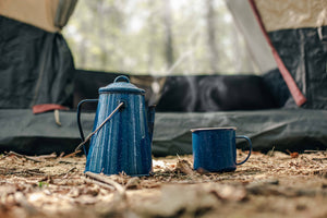 a blue coffee pot and mug on the ground